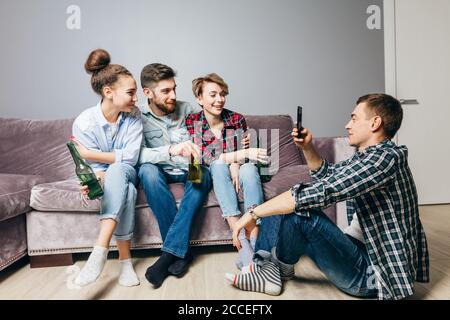 positive company is looking at the camera of the smartphone. full length photo Stock Photo