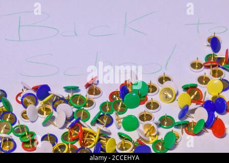 thumbtacks scattered on a white paper with the words "back to school", horizontal image Stock Photo
