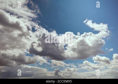 Cumulus clouds illuminated by bright sunlight in blue sky. Solar radiation. Background for forecast and meteorology illustration Stock Photo