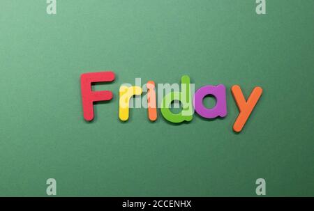 Friday word written with colorful letters on granite stone background ...