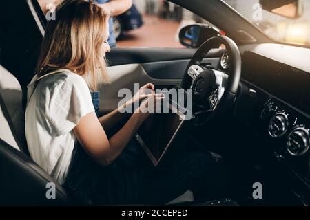 young woman controlling the car. close up side view photo. Stock Photo