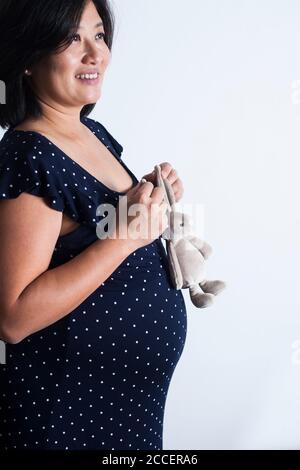 Pregnant woman holding soft toy Stock Photo