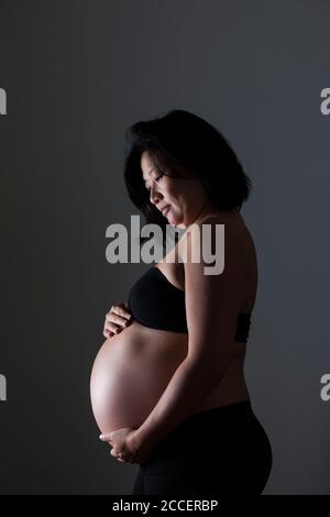 Pregnant woman holding her abdomen Stock Photo