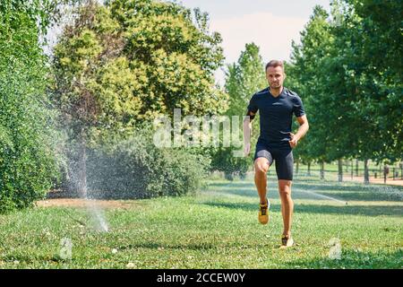 Young man training in a park, he is jogging. Concept of healthy life and sport. Healthy life. Stock Photo