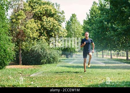 Young man training in a park, he is jogging. Concept of healthy life and sport. Healthy life. Stock Photo