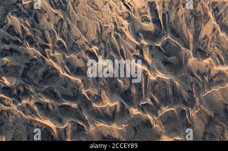 rippled wet sand background texture on beach at sunset Stock Photo