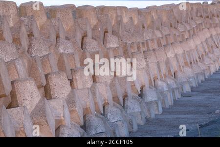 Early evening - a long wall of neatly stacked tetrapods lie along the coast in northern Japan Stock Photo