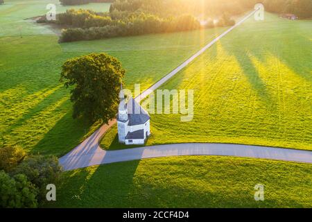 Chapel of St. Leonhard in Harmating at sunrise, at Egling, Tölzer Land, aerial view, Upper Bavaria, Bavaria, Germany Stock Photo
