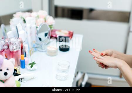 A bride putting on her wedding ring in front of the dressing table Stock Photo