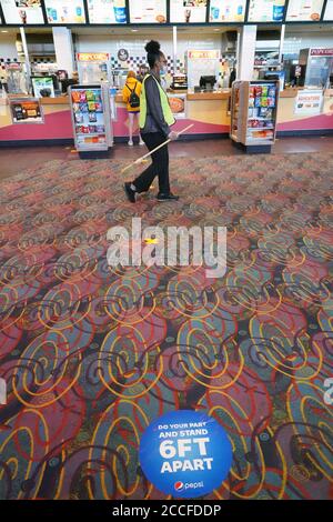 St. Charles, United States. 21st Aug, 2020. A St. Charles Cinema employee walks past social distancing marks on the floor in St. Charles, Missouri on Friday, August 21, 2020. After being closed for months due to the pandemic, movie theatres in the St. Louis area and across the country are reopening. The St. Charles Cinema, part of the Marcus Theaters chain, will do employee wellness checks, require mask wearing and perform frequent cleanings, especially in high touch areas. Photo by Bill Greenblatt/UPI Credit: UPI/Alamy Live News Stock Photo