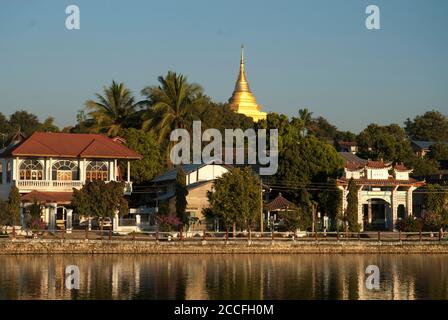 The golden spire of Wat Jom Kham overlooks the Naung Toung Lake at Kengtung, Shan State, Myanmar (Burma) Stock Photo