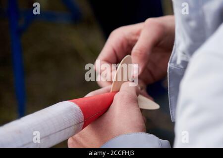 The guy holds in his hands a model of a miniature rocket and prepares it for flight. Stock Photo