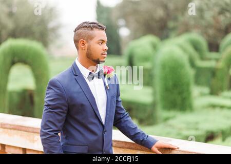 Wedding, groom, young man, diversity, garden, landscape orientation, looking away Stock Photo