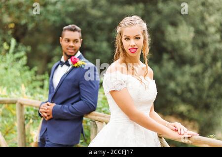 Wedding, newlyweds, young adults, diversity, love, garden, railing Stock Photo