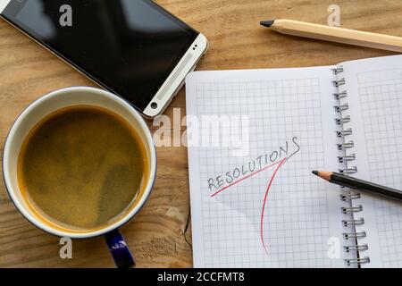 Business concept of top view resolution list with telephone, cup of coffee over wooden desk Stock Photo