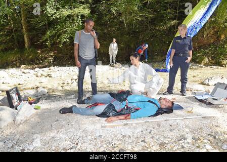 21 August 2020, Bavaria, Berchtesgaden: The actors Peter Marton (l-r, investigator Jerry Paulsen), Genoveva Mayer (medical examiner Sonja Bitterling) and Sarah Thonig (investigator Caro Reiser) with the 'corpse' of the crashed paraglider taken during a shooting scene in the crime series 'Watzmann ermittelt'. The broadcast of the new episodes is planned for early 2021 on Wednesdays at 18.50 on the eve of the first one. Photo: Ursula Düren/dpa Stock Photo