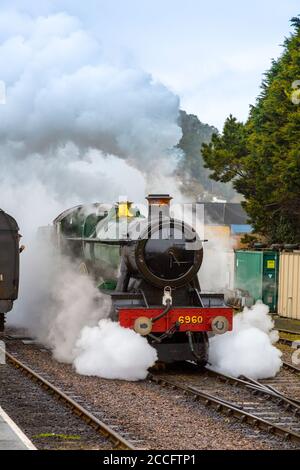 Ex-GWR steam loco 6960 'Raveningham Hall' makes dramatic departure from the engine shed at Minehead, West Somerset Railway Spring Gala, England, UK Stock Photo