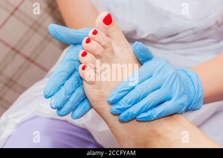 Pedicure moisturizing cram after dead skin remover foot rasp woman in nail salon. Stock Photo