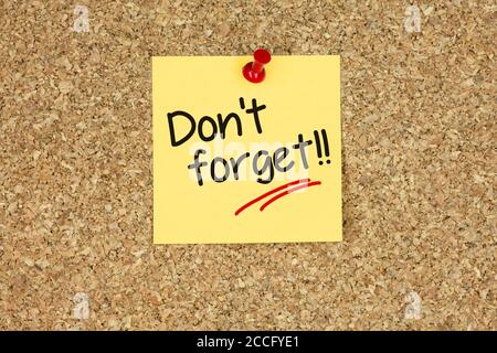 Don't forget text on yellow sticky note on corkboard Stock Photo