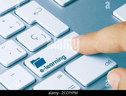 e-learning  Written on Blue Key of Metallic Keyboard. Finger pressing key. Stock Photo