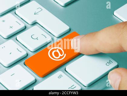Contact us Written on Orange Key of Metallic Keyboard. Finger pressing key. Stock Photo