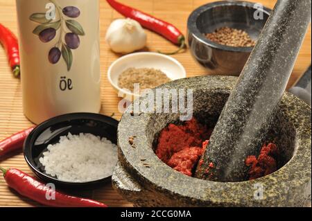 Harissa chili paste in a mortar with a pestle Stock Photo
