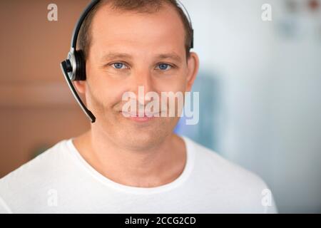 Call center concept. Smiling middle aged man with headset looking at camera. Close up portrait. Stock Photo