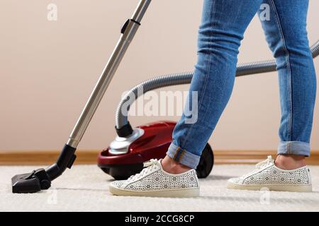 Close up of a woman vacuum-cleaning the carpet Stock Photo