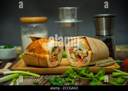 Snack at break time. Famous Vietnamese food is Banh mi thit and black coffee, popular street food from bread stuffed with raw material: pork, ham, pat