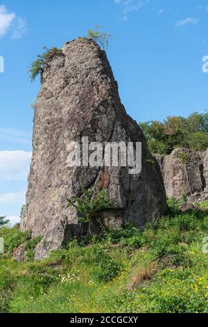 Rock pillar in front of a rock wall at Stenzelberg.against the blue sky. Stock Photo