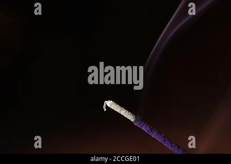 Closeup shot of a burning incense against a blurry background Stock Photo