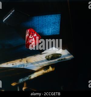Close up of a red transparent pyramid dice on a reflective surface Stock Photo