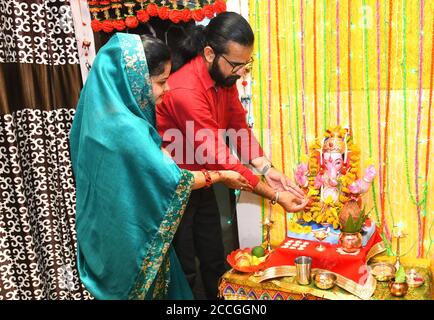 Beawar, Rajasthan, India, Aug 22, 2020: A young couple offer prayers to Lord Ganesha (Elephant-Headed Hindu Deity) at their home on the occasion of Ganesh Chaturthi festival amid COVID-19, in Beawar. Credit: Sumit Saraswat/Alamy Live News Stock Photo