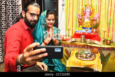 Beawar, Rajasthan, India, Aug 22, 2020: A young couple takes a selfie with Lord Ganesha (Elephant-Headed Hindu Deity) at their home on the occasion of Ganesh Chaturthi festival amid COVID-19, in Beawar. Credit: Sumit Saraswat/Alamy Live News Stock Photo