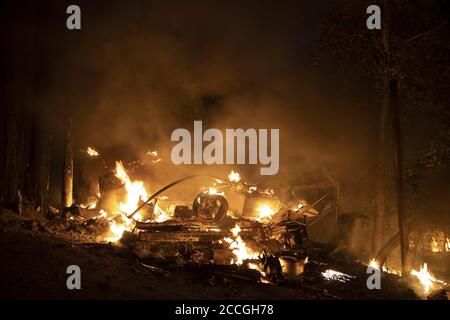 Boulder Creek, United States. 22nd Aug, 2020. The remains of a burned vehicle smolder in to the night in Boulder Creek, California as the CZU Lightning Complex fire continues to burn well into its fourth day with more than 50,000 acres torched, more than 100 structures destroyed and more than 75,000 people evacuated across two counties on Friday, August 21, 2020. Photo by Peter DaSilva/UPI Credit: UPI/Alamy Live News Stock Photo