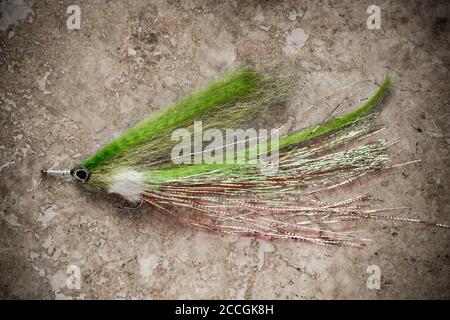 An old salmon fly, possibly homemade, from a collection of vintage fishing  tackle. Desaturated colours on a light stone background. Dorset England UK  Stock Photo - Alamy