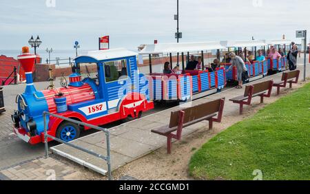 Visitors boarding the land train on the promenade at Bridlington in East Yorkshire Stock Photo