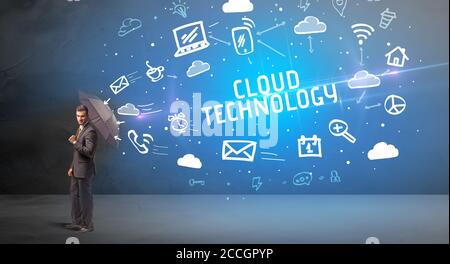 Businessman defending with umbrella from CLOUD TECHNOLOGY inscription, modern technology concept Stock Photo
