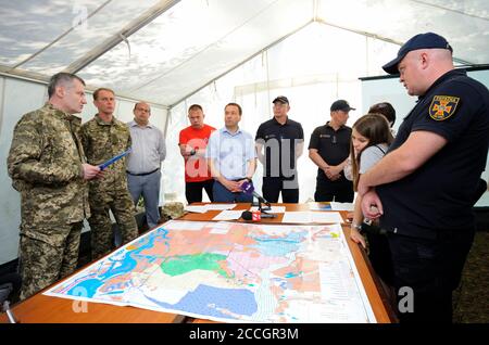 People standing in front of a table with maps. The headquarter of a firefighters, planning. June 5, 2019. Kievskaya oblast, Ukraine Stock Photo