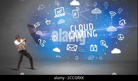 Businessman defending with umbrella from CLOUD GAMING inscription, modern technology concept Stock Photo