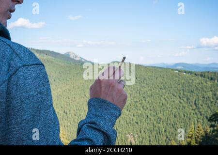 Close-up of young man smoking marijuana joint outdoors. Hemp blunt in the male hand. Cannabis is a concept of herbal and alternative medicine Stock Photo