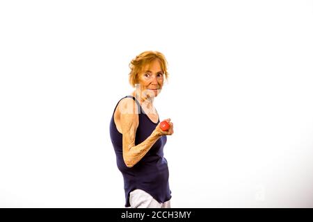 Senior Woman Looking Away While Lifting Two Pound Dumbbells Stock Photo