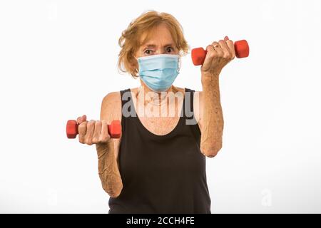 Thin Senior Woman Determined To Lift Two Pound Dumbbells Stock Photo
