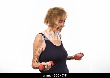 Thin Senior Woman Concentrating On Lifting Two Pound Dumbbells Stock Photo