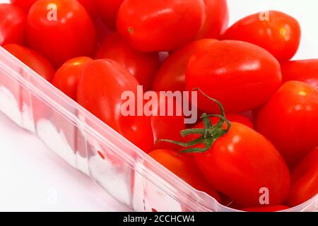 Baby plum tomatoes in a plastic punnet isolated on a white background Stock Photo