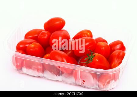 Baby plum tomatoes in a plastic punnet isolated on a white background Stock Photo