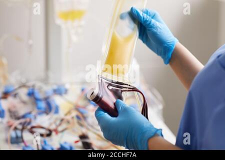 Close-up of nurse in protective gloves holding dropper with medicine and blood samples she working at the lab Stock Photo