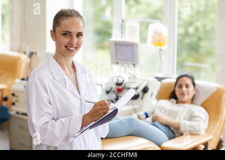 Portrait of female doctor smiling at camera while examining patient at the hospital Stock Photo