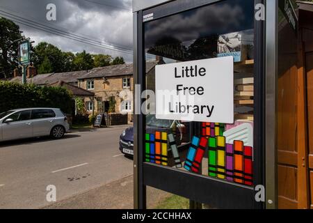 A little, free library in an Oxfordshire village, repurposing an old phone box Stock Photo