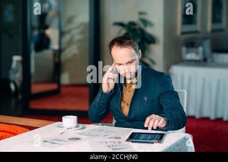 Man Working in Office and Analyzing Some Statistical Calculation Reports. Stock Photo